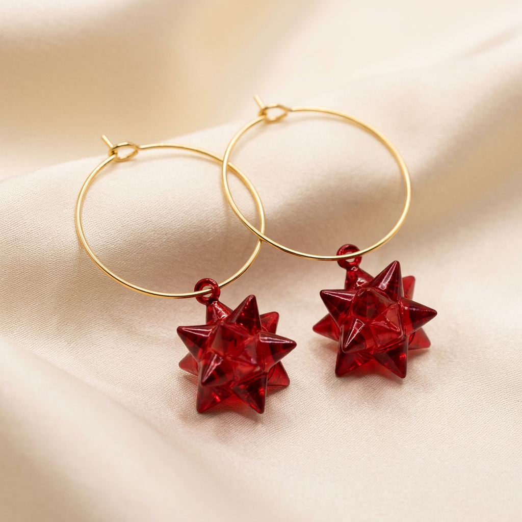 Red starburst charm hoop earrings on champagne satin