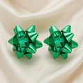 Pair of glossy green dimensional gift bow stud earrings on ivory satin