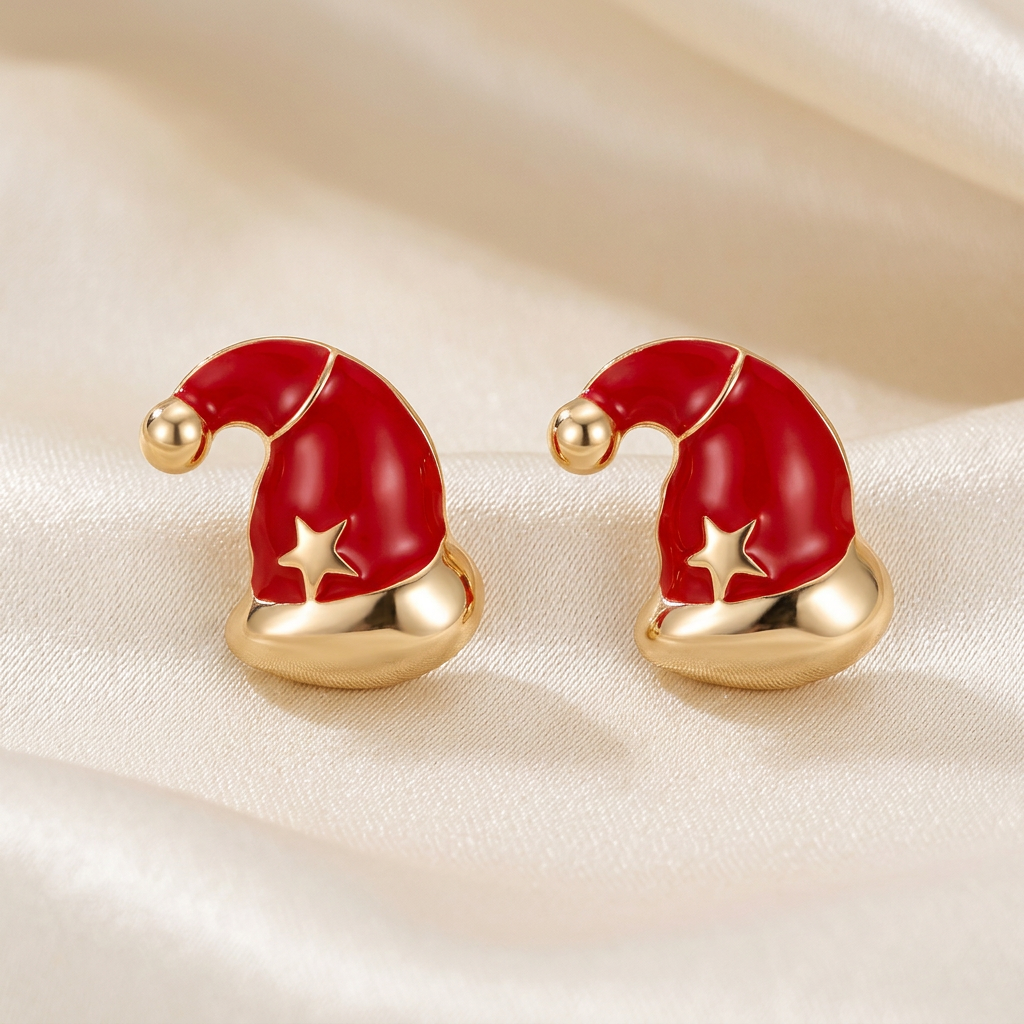 Pair of red Santa hat stud earrings with gold-tone bands, pom-poms, and stars on ivory satin