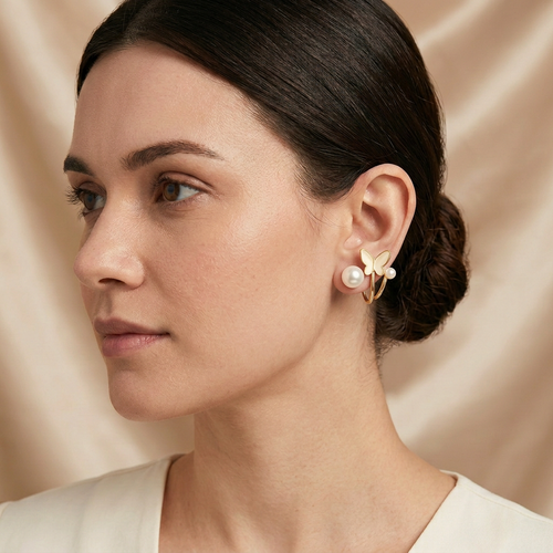 Model wearing butterfly ear jacket earrings with pearl-look stud at the earlobe