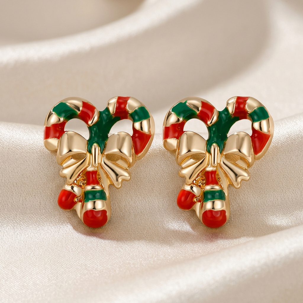 Pair of red-and-green candy cane stud earrings with gold-tone bows on ivory satin