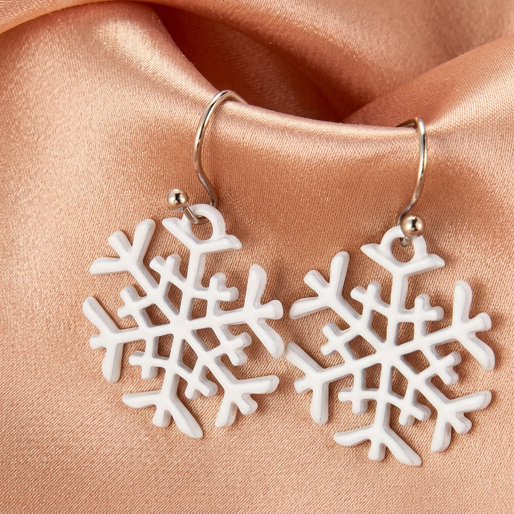 White openwork snowflake drop earrings on champagne satin