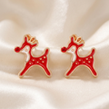 Pair of red enamel leaping reindeer studs with cream accents and gold-tone outlines on ivory satin