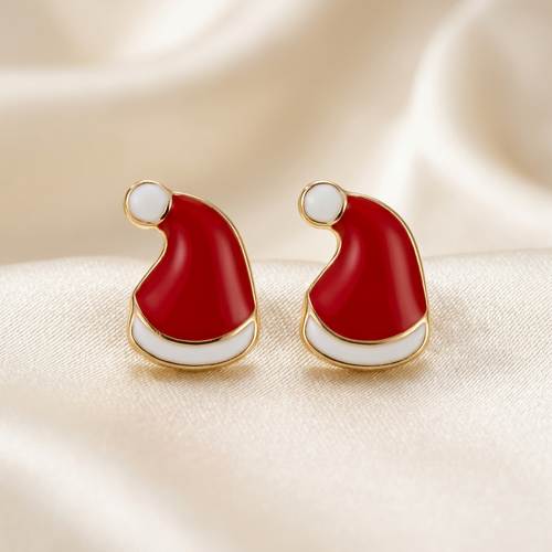Pair of red Santa hat stud earrings with white bands and pom-poms on ivory satin