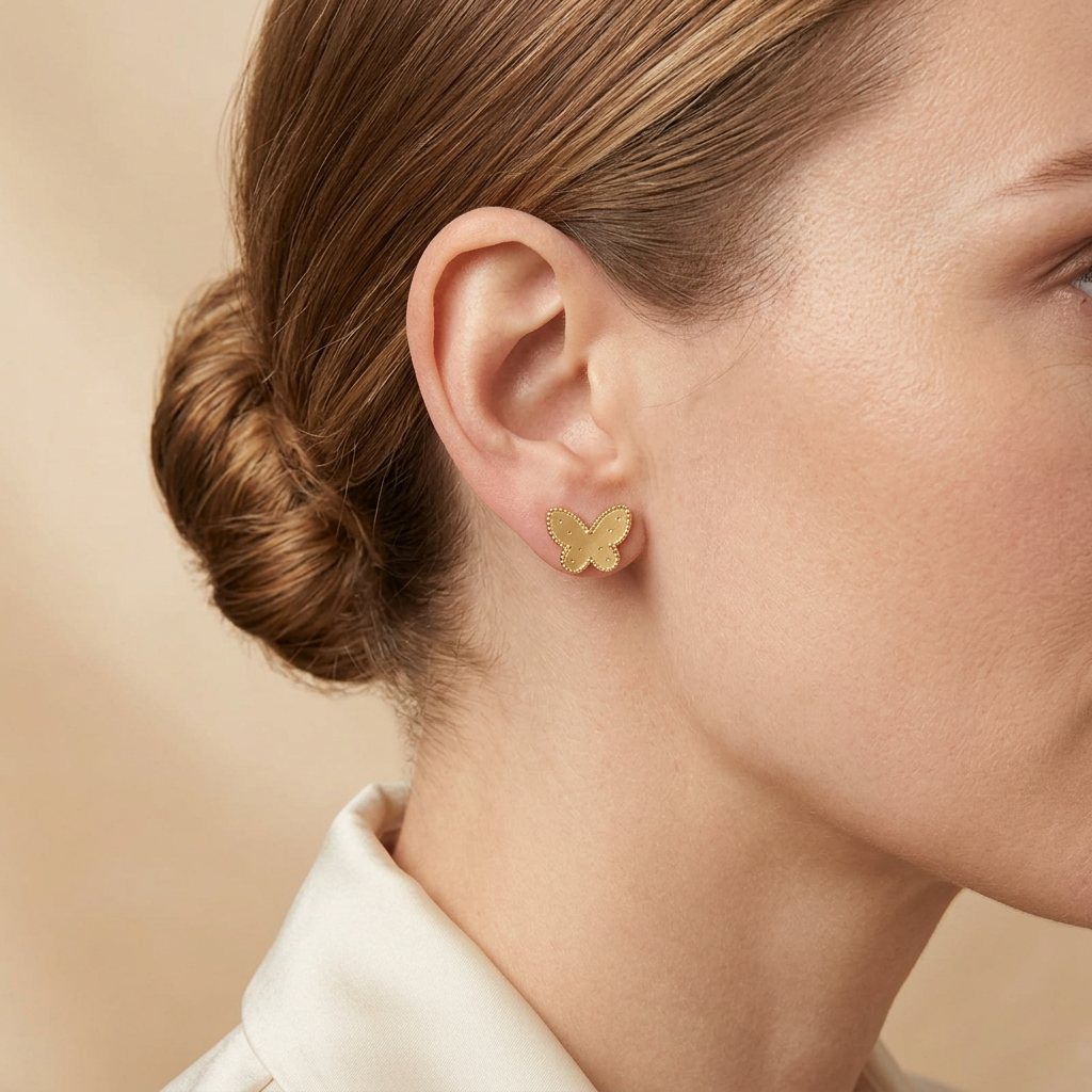Model wearing gold butterfly stud earrings matched to the actual product
