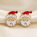 Pair of Santa face stud earrings with red hats, white beards, and red stone pom-poms on ivory satin