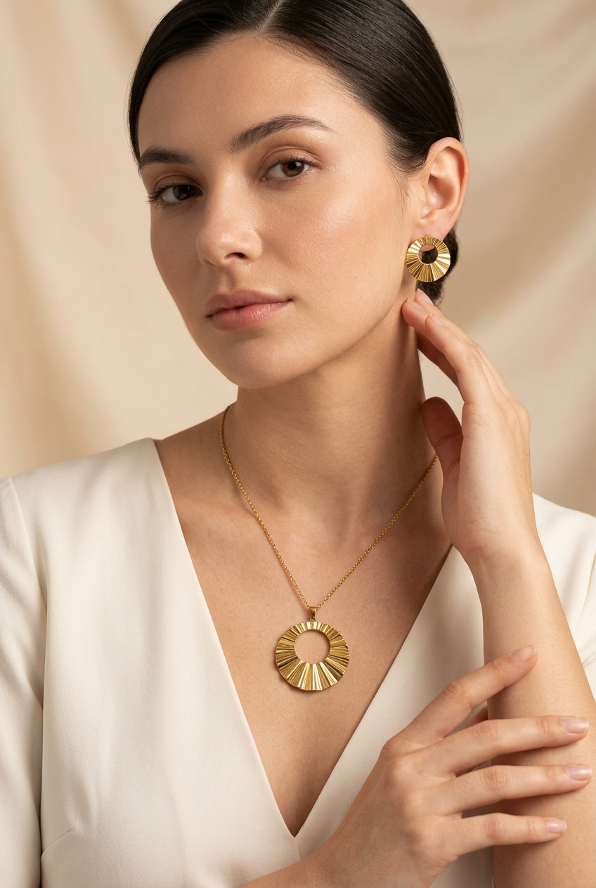 Model in an ivory V-neck dress wearing the gold-tone sunburst necklace and matching earrings