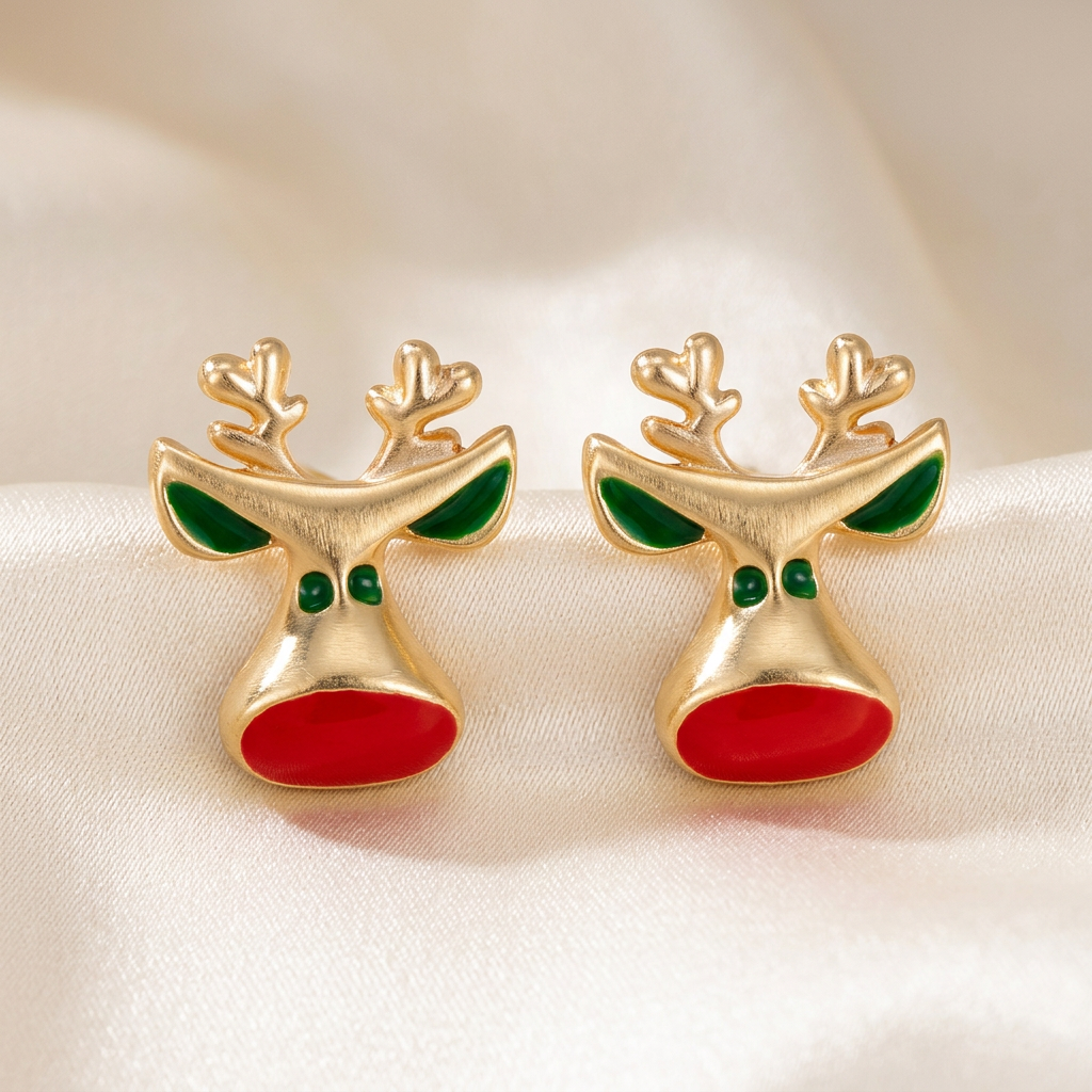 Pair of gold-tone reindeer stud earrings with green details and bright red oval noses on ivory satin
