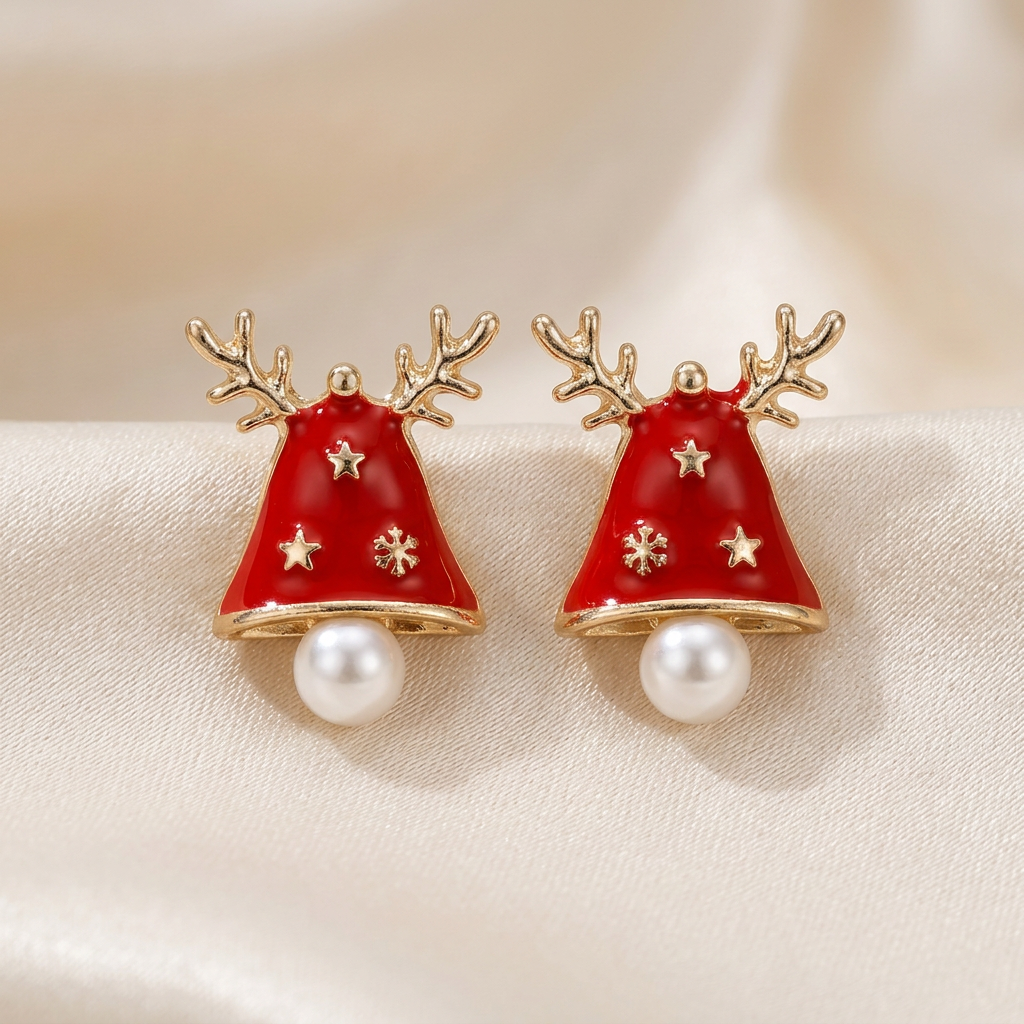 Pair of red Christmas bell studs with gold-tone antlers and white pearl-like accents on ivory satin