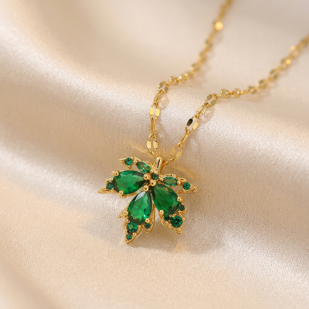 Gold-tone green stone leaf cluster necklace on ivory satin